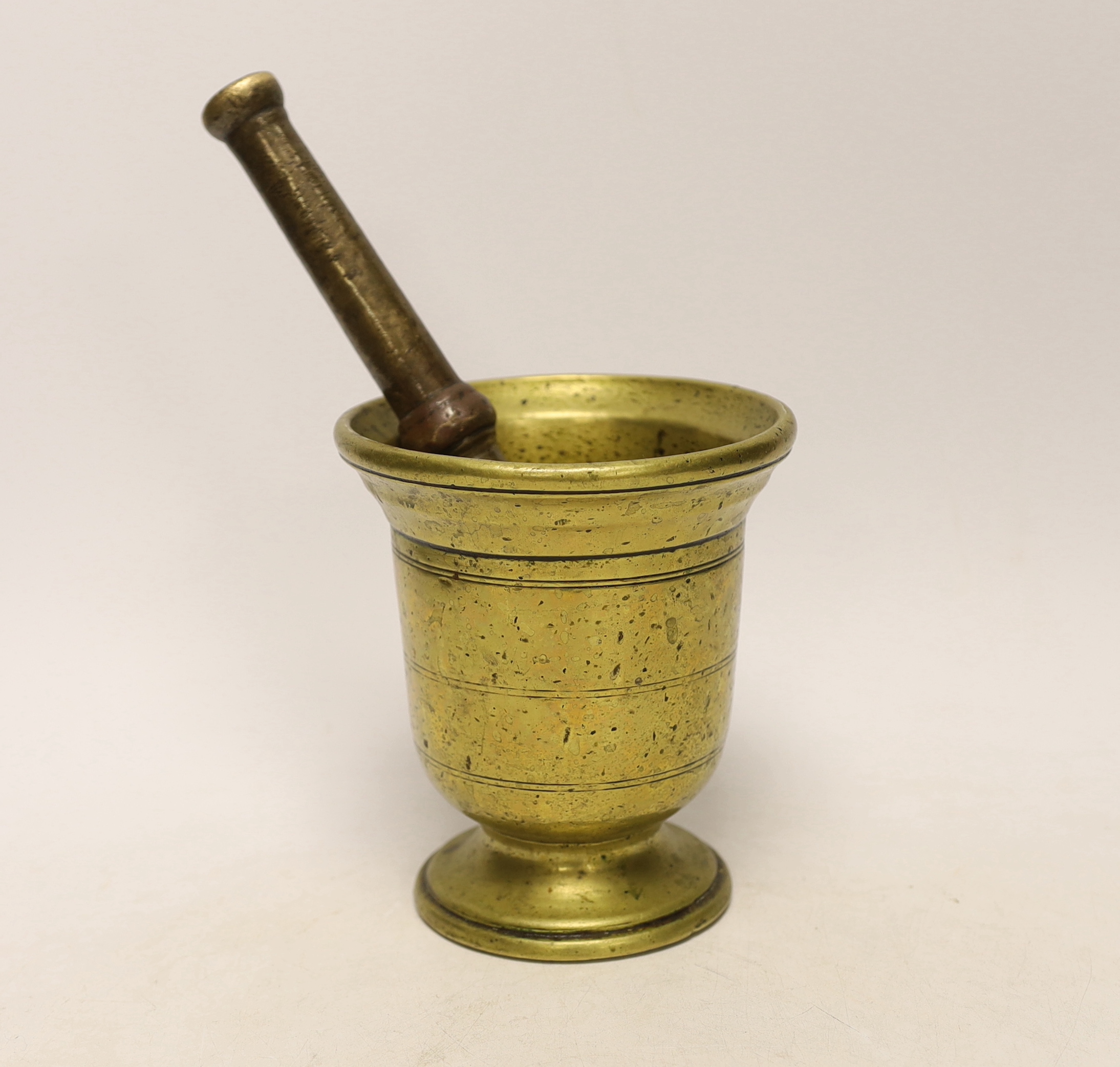 An antique bronze pestle and mortar, 15cm high